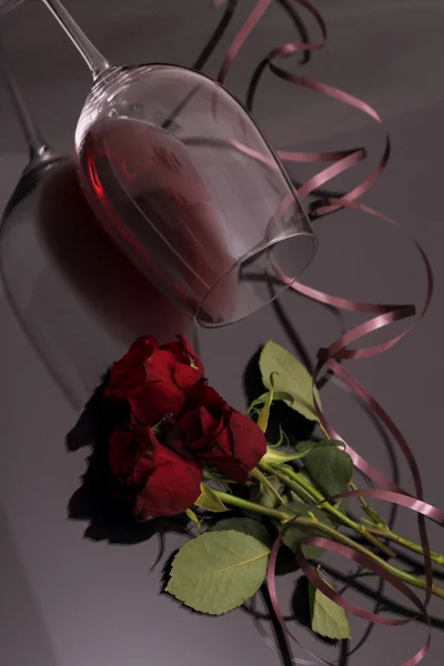 Bouquet of roses and glass red wine on black — Stock Photo, Image