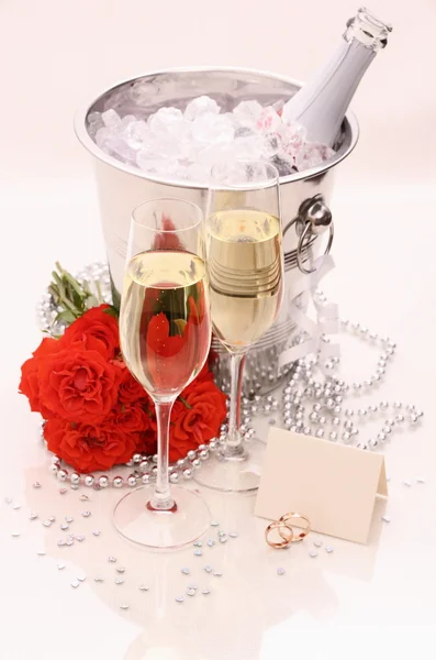 Två gyllene vigselringar, kort, champagne glas — Stockfoto