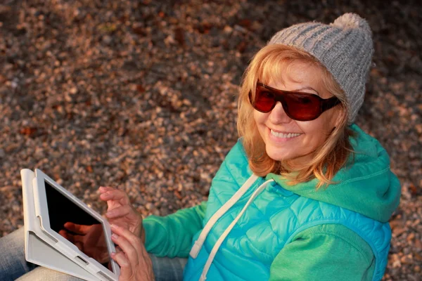 Счастливая женщина с планшетом в солнечных очках — стоковое фото