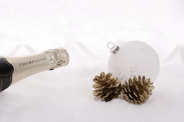 Botella de champán en nieve con bola de árbol de Navidad —  Fotos de Stock