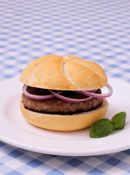 Hamburger on plate, white and blue checkered tablecloths — Stock Photo, Image