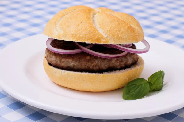 Hamburger on plate, on white blue checkered tablecloths — Stock Photo, Image