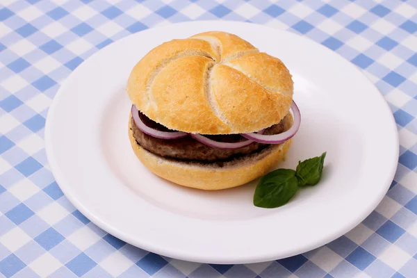 Hamburger plaka, beyaz mavi kareli masa örtüsü üzerinde — Stok fotoğraf