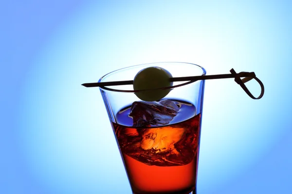 Short drink sklo s červenou tekutinu, olivový, kostky ledu — Stock fotografie