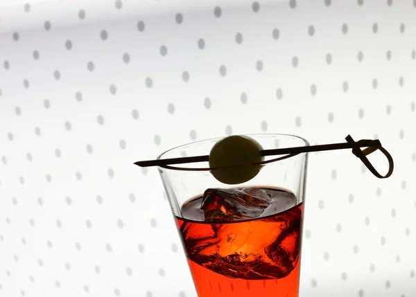 Gelas minuman pendek dengan cairan merah, zaitun, es batu — Stok Foto