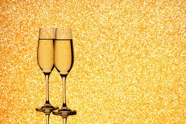 Two champagne glasses on blurred golden background — Stock Photo, Image