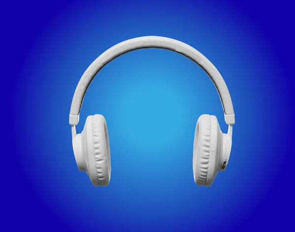 White headphones on blue spotlight background — Stock Photo, Image