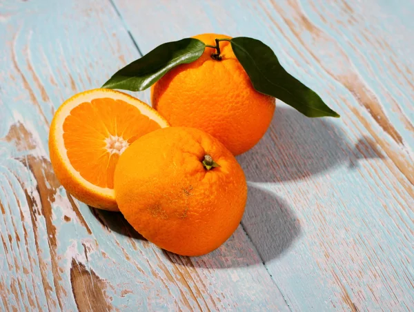 Fruta naranja grande madura con hoja sobre fondo de madera — Foto de Stock
