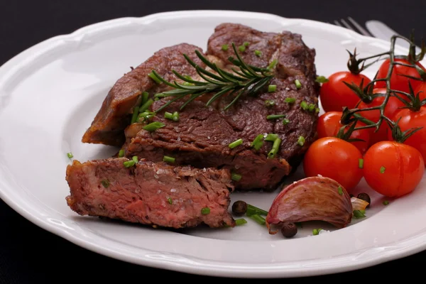 Rib eye steak with garlic, cherry tomatoes, herbs — Stock Photo, Image