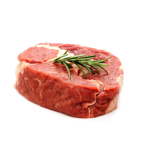 Raw ribeye steak garnished with sprig of rosemary — Stock Photo, Image