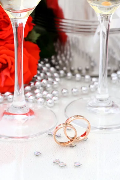 Dos anillos de boda dorados, copas de champán — Foto de Stock