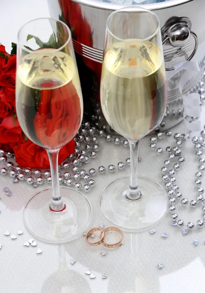 Two golden wedding rings, champagne glasses — Stock Photo, Image