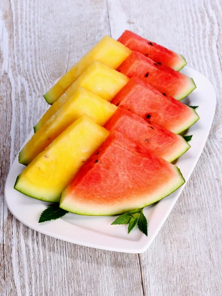 Gelbe und rote Wassermelone und Minze auf weißem Teller — Stockfoto