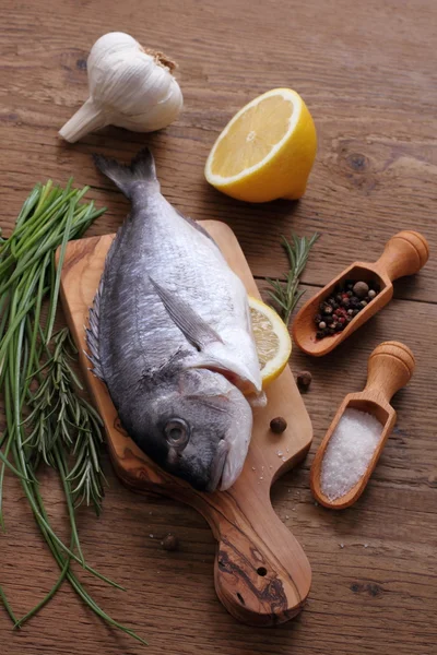 Dorade mit Zutaten auf Schneidebrett — Stockfoto