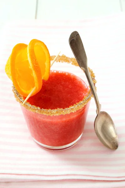 Strawberry smoothie gegarneerd met oranje segment, bruine suiker — Stockfoto