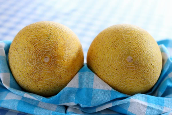 Melon galia dwa na ręcznik kuchenny kratkę biało niebieski — Zdjęcie stockowe