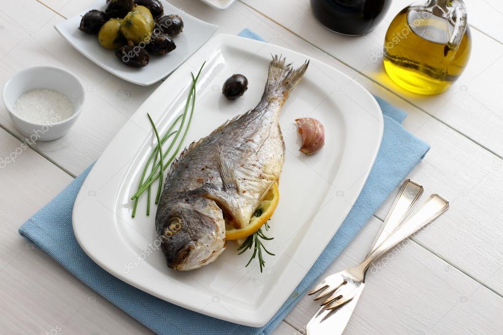 Garnished grilled whole sea bream with olives