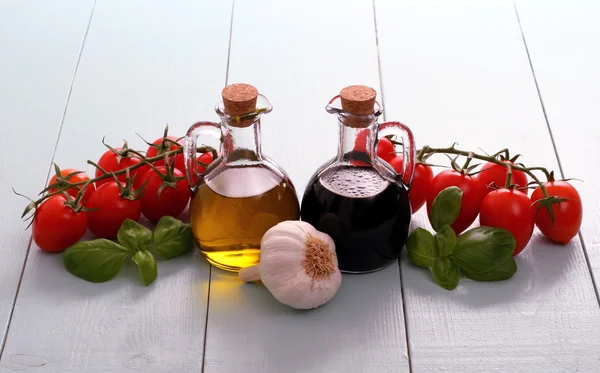 Olijfolie en azijn in flessen op houten tafel — Stockfoto