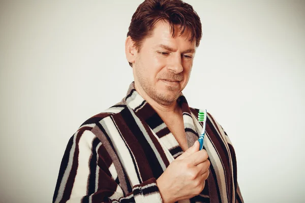 Diş fırçalama bornoz şaşırmış adam — Stok fotoğraf