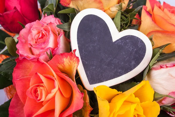 Roses and writing board in heart shape — Stock Photo, Image