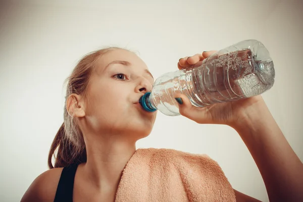 व्यायाम केल्यानंतर अल्पवयीन मुलगी बाटलीबंद पाणी पिते — स्टॉक फोटो, इमेज