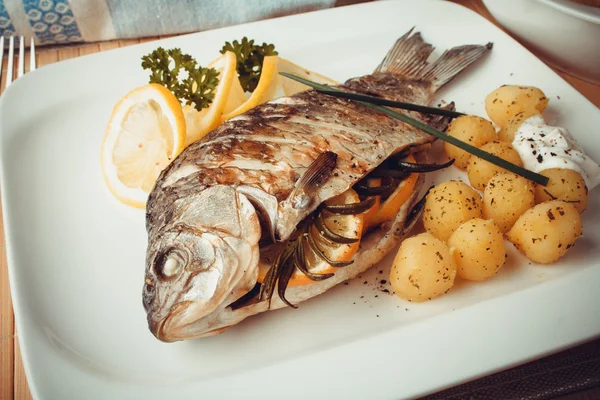 Carpa de peixe grelhada com batatas de alecrim e limão — Fotografia de Stock