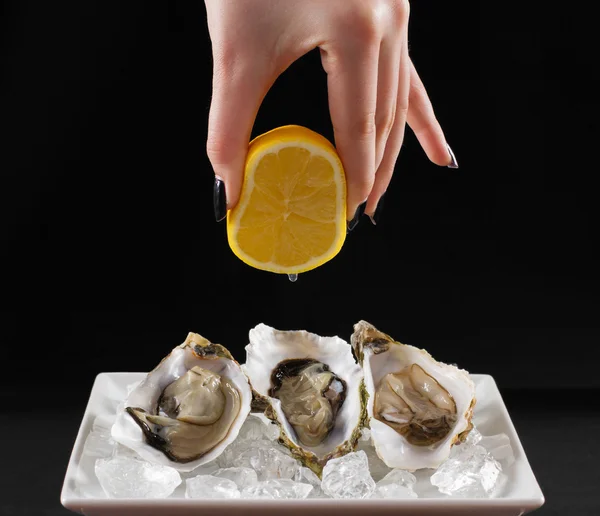 Girl hand, three oyster shell with lemon juice — Stock Photo, Image