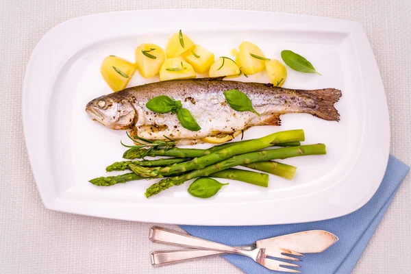 Gegrillte Forelle mit grünem Spargel und Rosmarinkartoffeln — Stockfoto