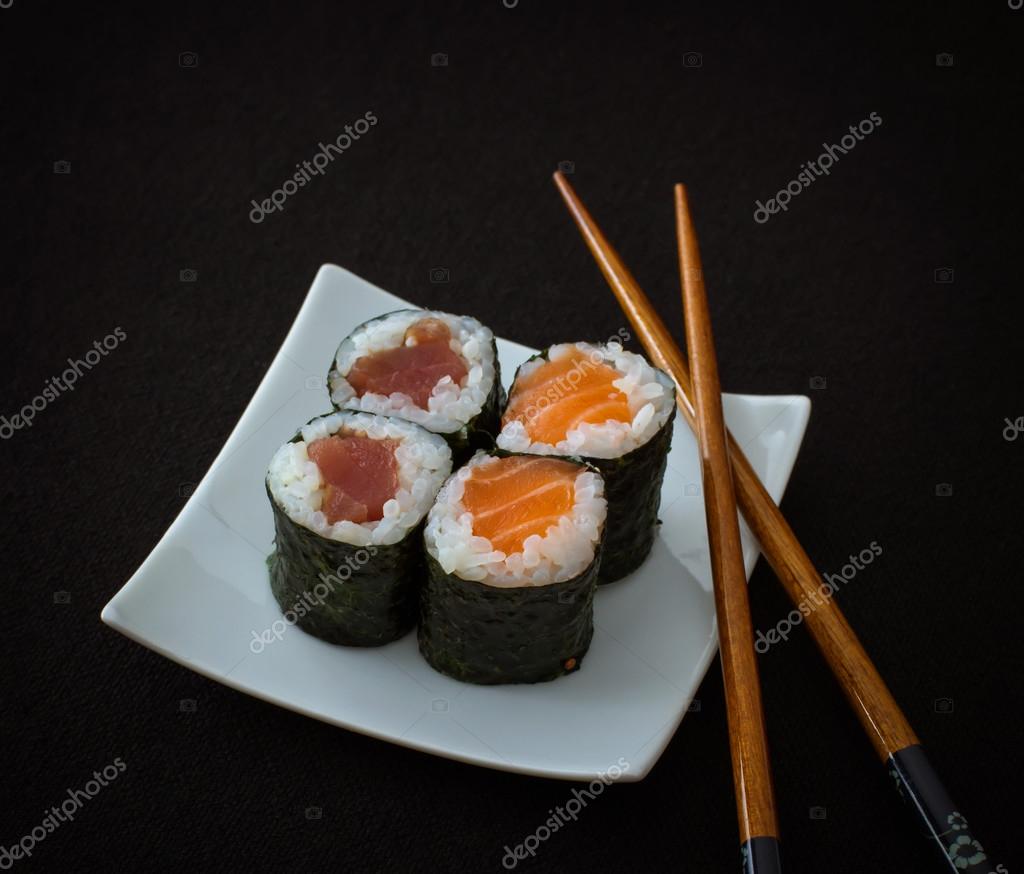 Lachs, Thunfisch Maki Sushi und Essstäbchen auf schwarz ...