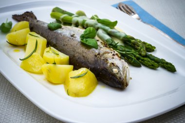 Gegrilde forel met groene asperges en rozemarijn aardappelen