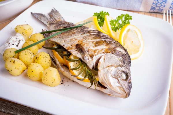 Poisson de carpe grillé avec pommes de terre romarin et citron — Photo