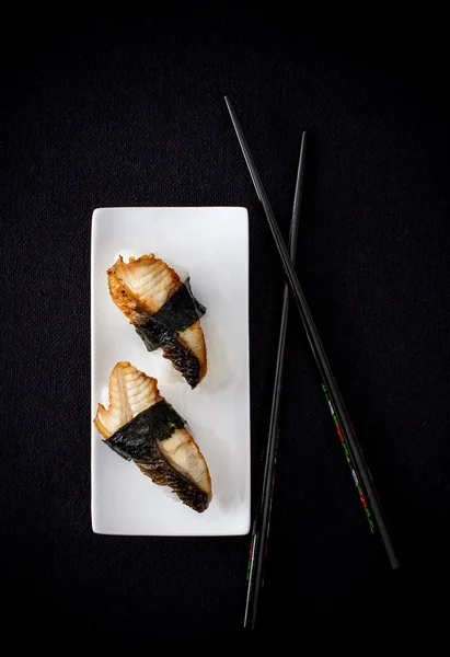 İki nigiri yılan balığı suşi yemek çubuğu ile — Stok fotoğraf