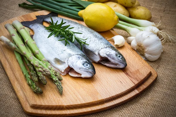 Raw trout with green asparagus, lemon and ingredients — Stock Photo, Image