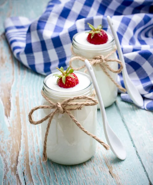 Twee glazen yoghurt met aardbeien op houten — Stockfoto