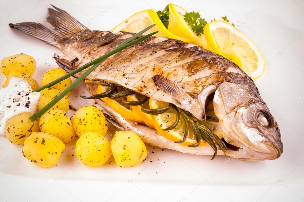 Grilled carp fish with rosemary potatoes and lemon