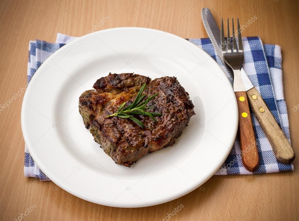 Juicy grilled rib eye steak with cutlery