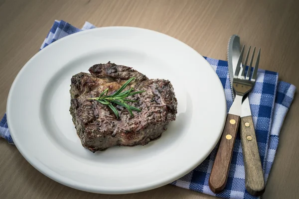 Juicy grilled rib eye steak with cutlery, top view — Stock Photo, Image