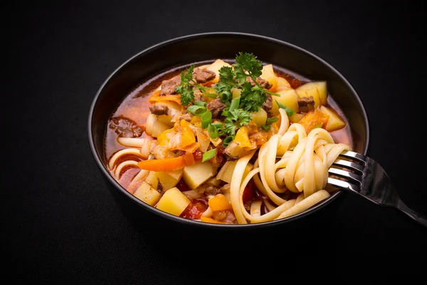 Sopa de macarrão uzbeque Lagman em preto, close — Fotografia de Stock