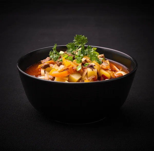 Uzbek noodle soup Lagman on black — Stock Image Uzbek noodle soup Lagman on black Royalty Free Stock Photos
