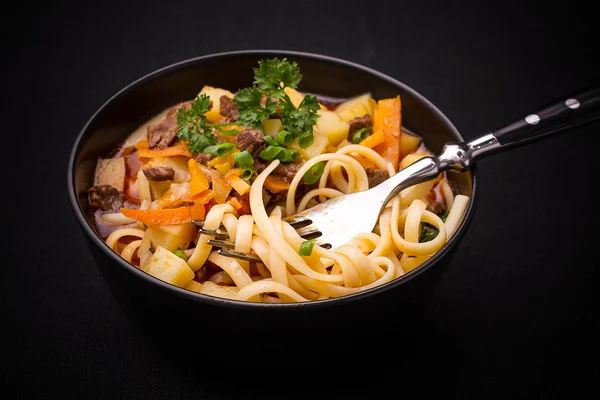 Uzbek noodle soup Lagman on black — Stock Image Uzbek noodle soup Lagman on black Stock Picture