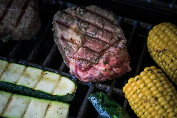 Rib eye steak with zucchini and corn on grill — Stock Photo, Image