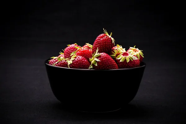 Rijp verse aardbeien in kom op zwart — Stockfoto