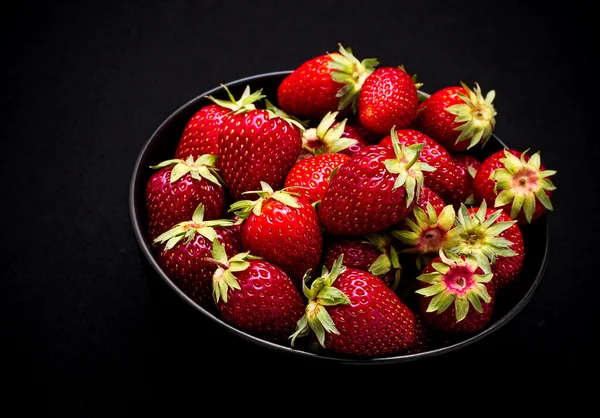 Rijp verse aardbeien in kom op zwart — Stockfoto