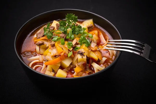 Uzbek noodle soup Lagman on black — Stock Image Uzbek noodle soup Lagman on black Stock Picture