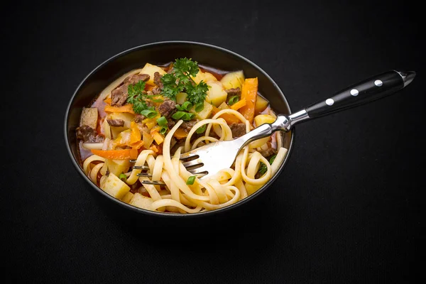 Uzbek noodle soup Lagman on black — Stock Image Uzbek noodle soup Lagman on black Royalty Free Stock Photos