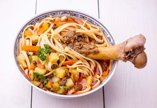 Uzbek noodle soup Lagman with large bone — Stock Image Uzbek noodle soup Lagman with large bone Royalty Free Stock Photos