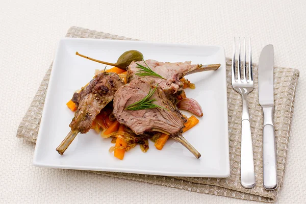 Racks of lamb with carrot, onion and garlic — Stock Photo, Image