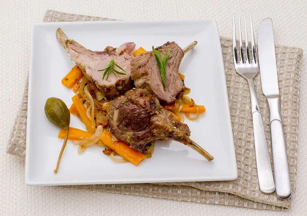 Rastrelliere di agnello alla griglia con carota e capperi — Foto Stock