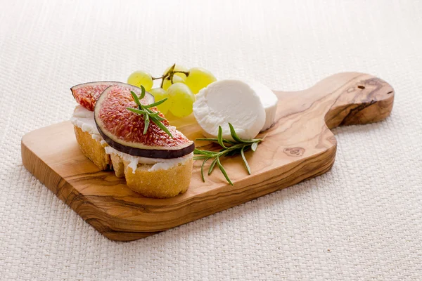 Goat cheese with ripe figs and grapes — Stock Photo, Image