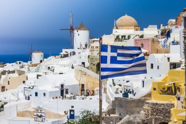 Mavi gökyüzü ve geleneksel beyaz köy yakınındaki bayrağı